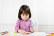 © M-image - toddler girl practice writing letters on white paper against white background