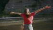 © koshkin_stock - Shot back attractive young woman with her hands raised stand near river forest outdoor travel adventure female tourist water beautiful tourist relaxation freedom landscape slow motion