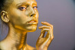 © de Art - woman golden skin face in bright sparkles, Trendy glowing gold skin make-up. Glitter metallic shine makeup