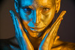 © de Art - woman golden skin face in bright sparkles, Trendy glowing gold skin make-up. Glitter metallic shine makeup