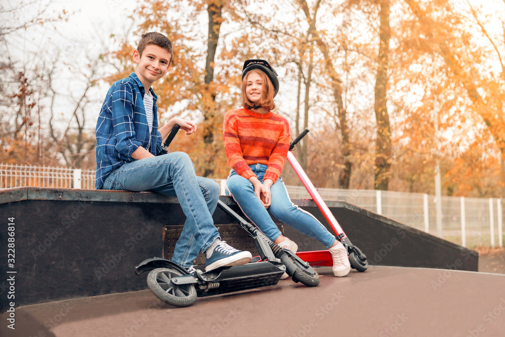 Active teenagers with kick scooters outdoors