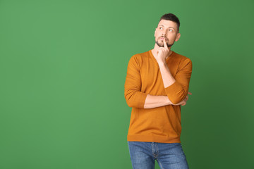 Wall Mural - Thoughtful man on color background. Concept of choice