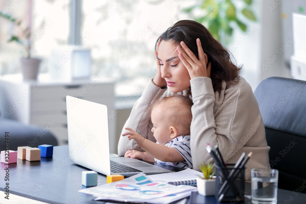 Stressed mother with her baby working in office - obrazy, fototapety, plakaty 