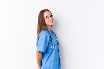 Wall Mural - Young nurse woman isolated looks aside smiling, cheerful and pleasant.