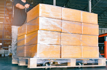 Poster - Worker working with hand pallet truck unloading shipment goods in warehouse, Cargo export, Courier delivering  shipment package boxes