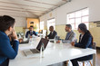© Mangostar - Group of concentrated marketing experts during morning briefing. Focused workers sitting at table and discussing some business issues. Business meeting, teamwork concept