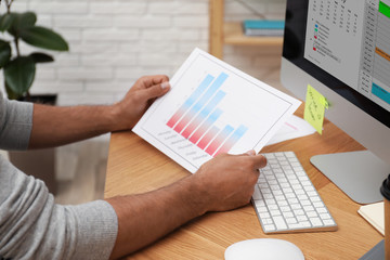 Canvas Print - Man working with calendar at table in office, closeup