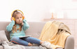 © New Africa - Cute little girl with headphones and tablet on sofa at home. Space for text
