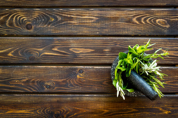 Wall Mural - Herbs in ceramic mortar with pestle on dark wooden backgroud top-down copy space