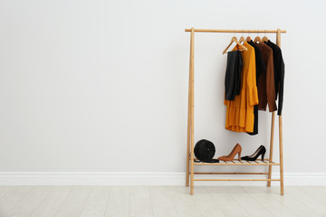 Wall Mural - Wooden rack with stylish clothes in room. Space for text