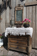 Wall Mural - Antique russian furniture and retro interior in details. Ancient iron, antiquarian mirror and vintage silver samovar for tea drinking. Russian style in interior decor. Blossoming home geranium in pot