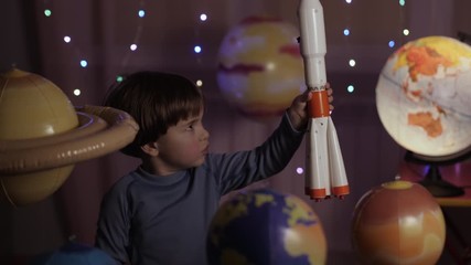 Wall Mural - Space Travel Game Inspiration Spaceship. Little Kid Boy Astronaut Launching Toy Rocket From Spaceport Through Planets. Child Dreamer Playing With Toy Space Rocket Flying Among Planets. SLOW MOTION.