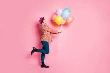 Poster - Full body profile photo of cute lady hold many colorful air balloons birthday surprise wear stylish fur coat scarf beret cap pants shoes clothes isolated pink color background