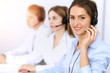 © rogerphoto - Call center. Focus on beautiful business woman using headset in sunny office