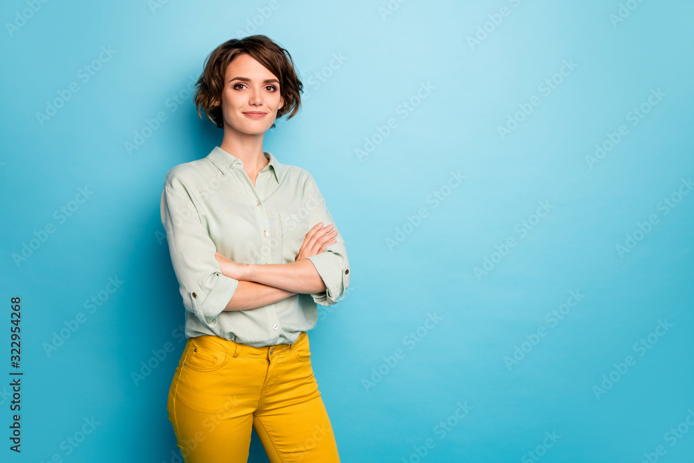 Photo of attractive pretty business lady short hairstyle friendly smiling responsible person arms crossed wear casual green shirt yellow pants isolated blue color background - obrazy, fototapety, plakaty 