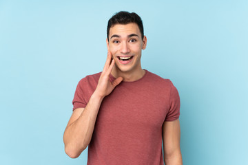 Young caucasian handsome man isolated on blue background with surprise and shocked facial expression