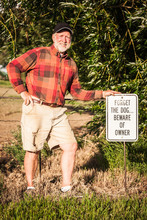 Farmer Standing Next To Funny Sign In His Driveway. Laurel, Montana, USA
