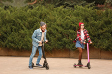 Young Couple With Kick Scooters Outdoors