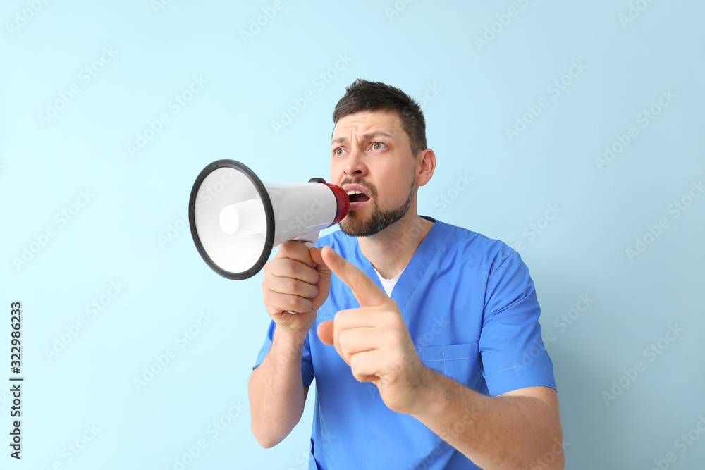 Emotional man with megaphone on color background