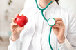 © Pixel-Shot - Female cardiologist with red heart in modern clinic