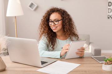 Wall Mural - Young African-American businesswoman working at home