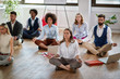 group of business coworkers meditating at work, sitting on the floor. modern, business, meditation concept