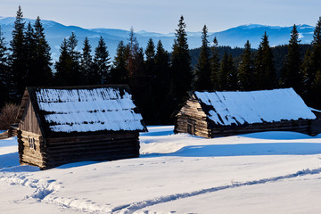 snow-capped mountain huts, sunset over winter mountains