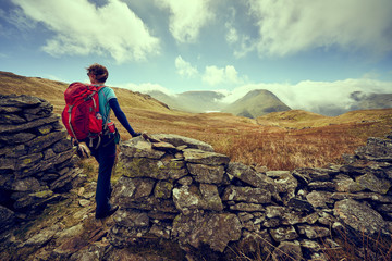 Sticker - A female hiker taking in the mountain views of Hayeswater, the summits of Gray Crag, Thornthwaite and a cloud covered Stony Cove Pike in the distance. Lake District UK.