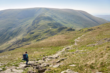 Poster - A hiker backpacking, walking in the mountains in the Lake District below Mardale Ill Bell with Harter Fell in the distance.