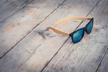 Wall Mural - sunglasses lie on a wooden table outdoors