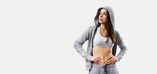 Studio photo of attractive positive young sporty woman with long hair in hood looking positively