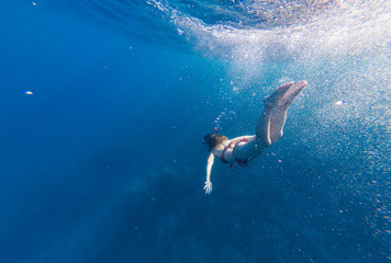  Girl with a mask and a snorkel dives into the sea with corals and fish