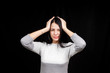© Kateryna - Portrait of beautiful young brunette wore a white sweater touching her temples, the feeling of stress, on black background