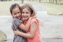 Happy And Healthy Mixed Race Multiethnic Young Little Girls Hugging And Smiling In The Park, Best Friend Kids And Children Friendship, Equality, Positive Mental Health Wellness Concept