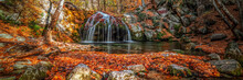 Waterfall In The Forest In Autumn Among The Fallen Colorful Bright Leaves.