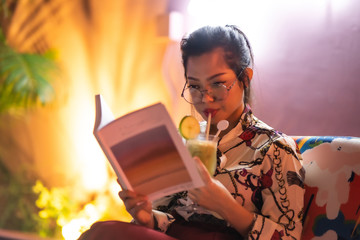 beautiful asian woman with neon light background reading book
