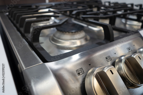 close up of modern stainless steel cooking range burners and buttons