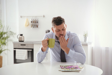 Sticker - Sleepy man with cup of drink at home in morning