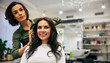 © My Ocean studio - How about that? Professional hairdresser is making a new hairstyle to a young beautiful happy brunette woman in a beauty salon.