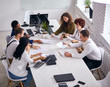 © alfa27 - Top view on business partners working on laptop, tablet and documents papers with diagram. Men and women team have brainstorm discussion in white office