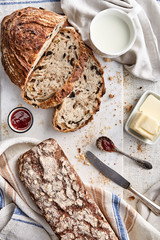 Wall Mural - Sliced bread on a marble background viewed from above. Whole grain bread breakfast with butter and milk. Top view