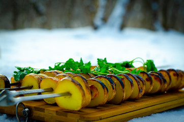 Potato skewers cooked on the grill. Background for cooking on an open fire.