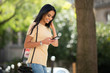 © mimagephotos - beautiful young smiling woman looking at mobile phone outside