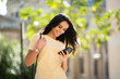 © mimagephotos - smiling young woman looking at mobile phone outside in city
