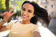© mimagephotos - selfie portrait smiling young hispanic woman with peace hand sign