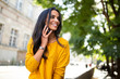 © mimagephotos - Close up smiling young latin woman talking with cellphone in city