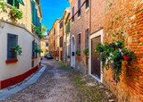 Fototapeta Uliczki - Cozy narrow street in Ferrara, Emilia-Romagna, Italy. Ferrara is capital of the Province of Ferrara