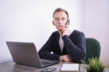 Portrait of young business man sitting at his desk desktop laptop technology in the office.Internet marketing, finance, business concept