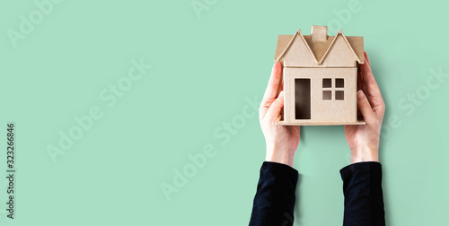 Cuadros en Lienzo Woman holding a cardboard house overhead view