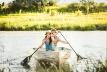 Two Young Adults Having Fun In A Swimming Lake While Rowing A Boat. Bridger, Montana, USATwo Young Adults Having Fun In A Swimming Lake. Bridger, Montana, USA